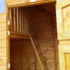 The interior of a wooden two storey Cottage Playhouse showcasing ladder access to a wooden balcony