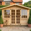 A wooden Georgian Summerhouse with double doors and opening windows on a timber frame on paving slabs