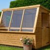 A 5ft x 7ft wooden Potting Shed with 3 large windows in a garden