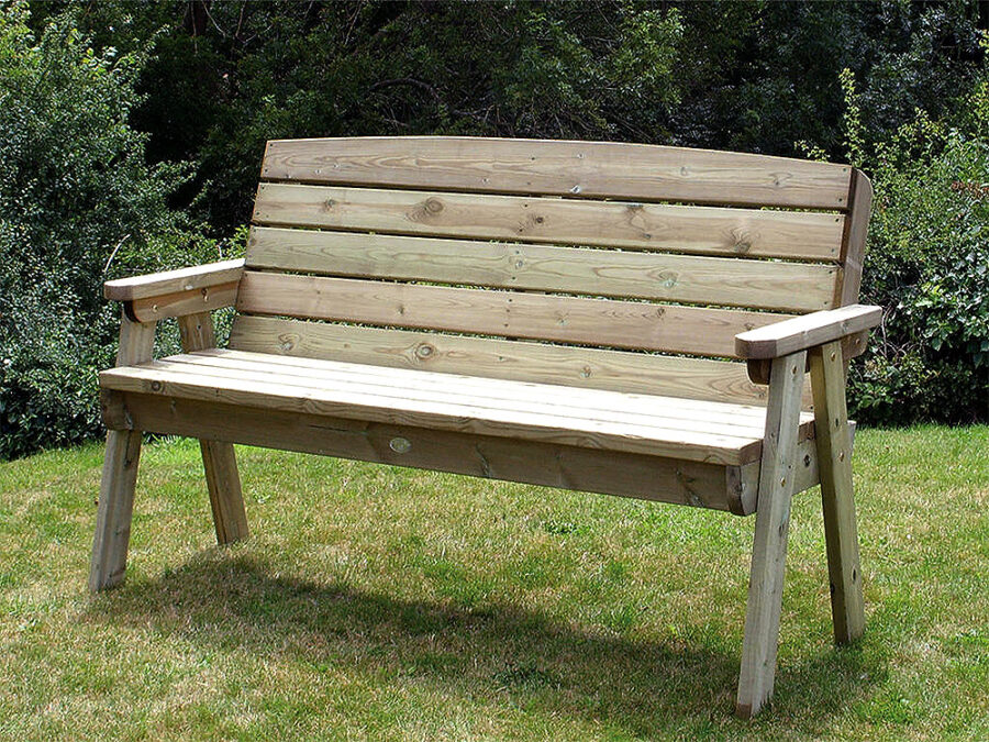A Hutton Dean 3 Seater wooden garden furniture in a grassy section next to bushes
