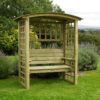 A stylish wooden Northwood Arbour product situated infront of bushes and trees in a large country garden