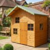 A wooden two storey Cottage Playhouse with a central wooden door and multiple windows on a brick floor in the Rutland Sheds showsite in Bearwood, West Midlands